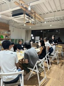 会議室で8人が楽しそうに話している